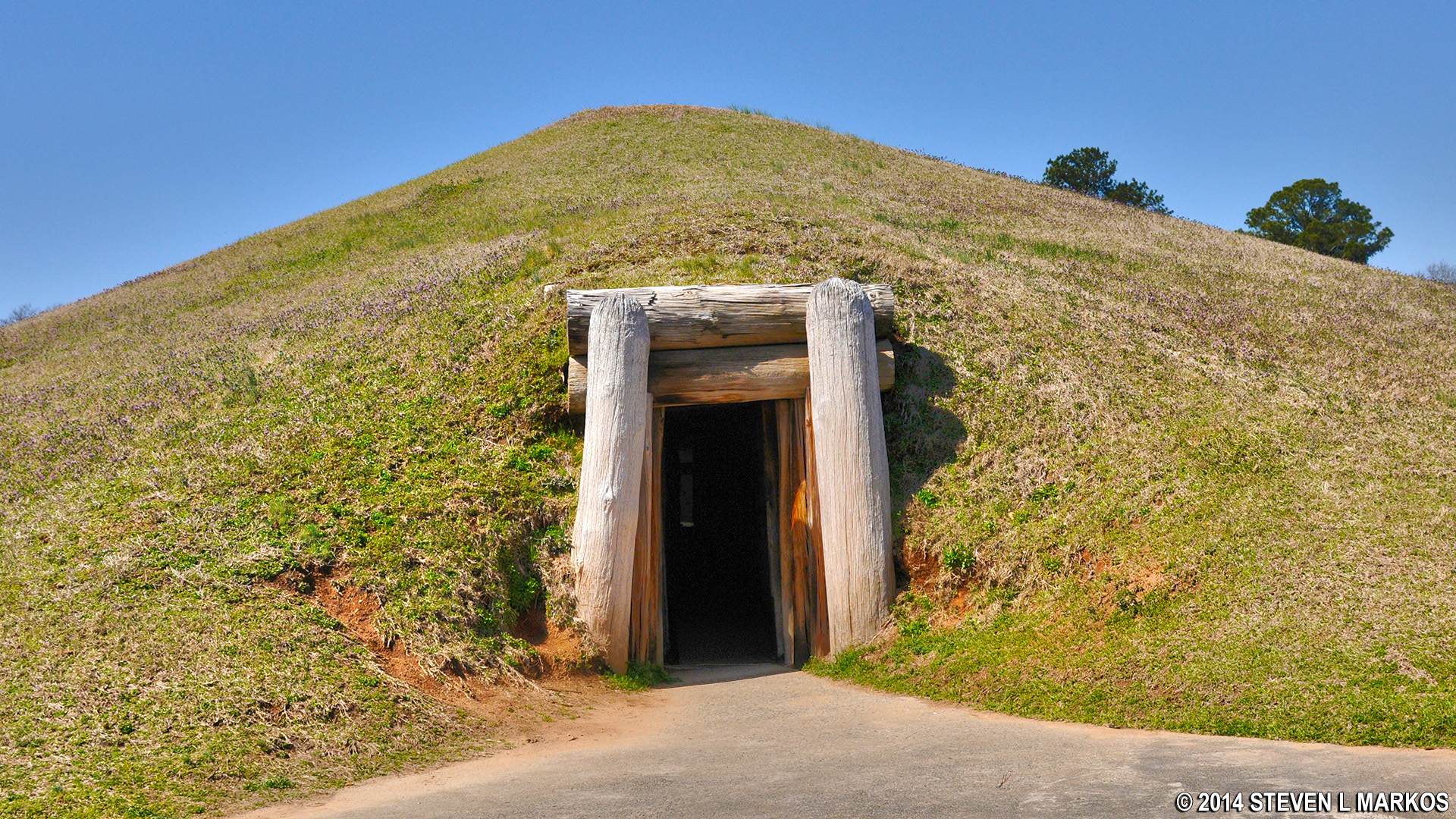 photo of entry to earthen lodge, covered with grass hill, with sky, day