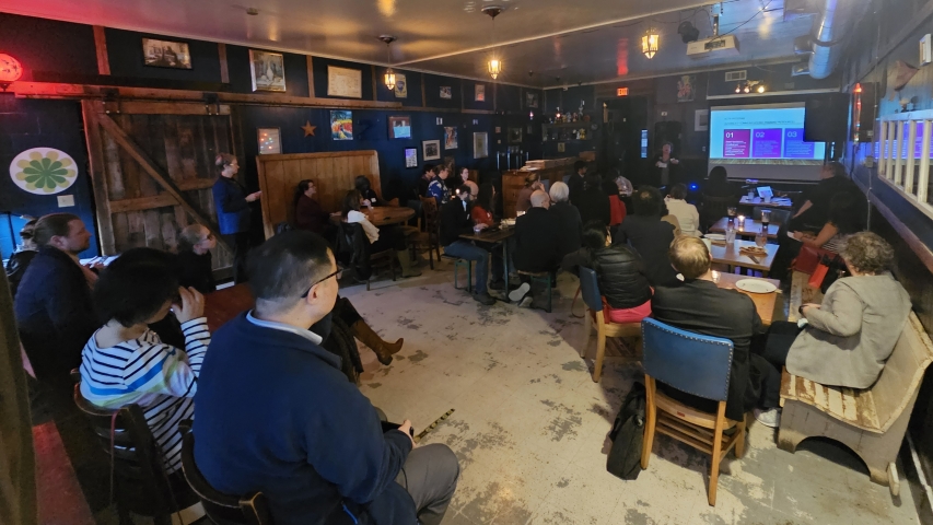 photo of people in room, with speaker and screen