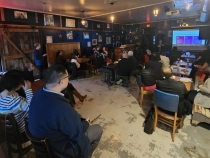 photo of people in room, with speaker and screen