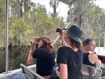 photo of people on boat in swamp