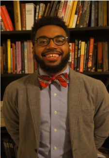 Photo of man in front of bookshelves