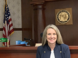 photo of woman, wait flag and state seal in background