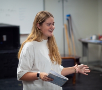 photo of woman holding notebook, arms extended