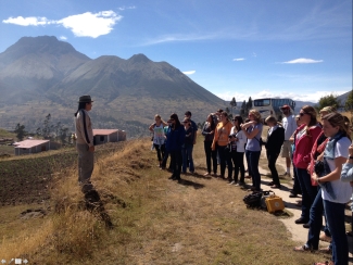 photo. of students with instructor, mountains and village in background