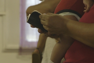 hands, hymnal, child's legs