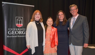 photo of four people, with banner