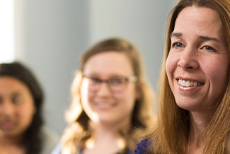 woman with two students in the background, photo