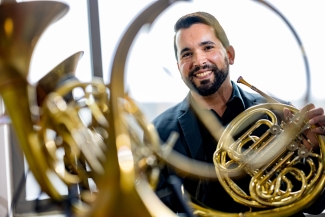 photo reflection of man with horn instrument