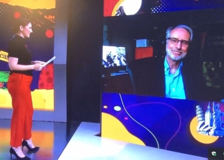 photo of woman interview man on screen in studio