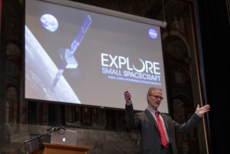 photo of man giving talk in front of screen