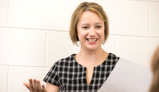 photo of woman holding paper, indoors