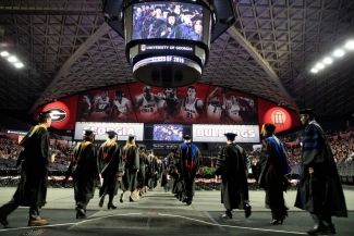 photo of people in caps and gowns inside the coliseum