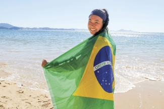 photo of woman on a beach with flag of Brazil