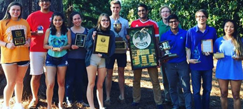students with plaques, trophies