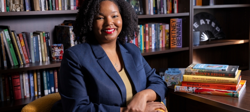 photo of woman in office, seated with books