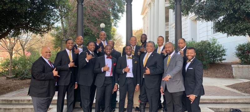 photo of men in suits in front of Arch, day