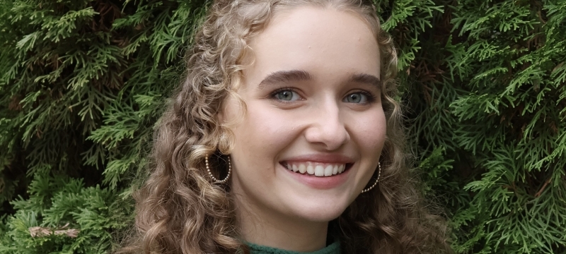 photo of woman, green foliage in background
