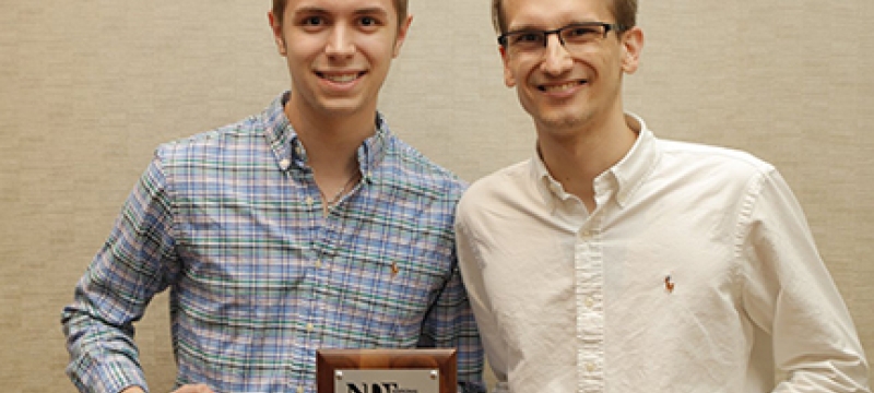 photo of two men with plaque and steins 