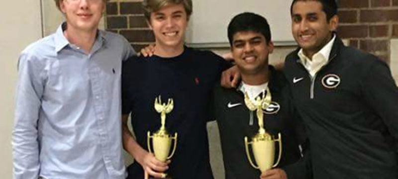 four male students with trophies
