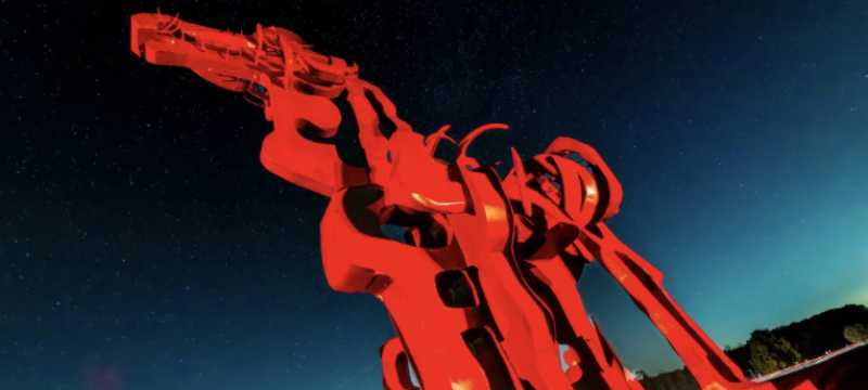 Photo of sculpture of horse, illuminated with red lights.