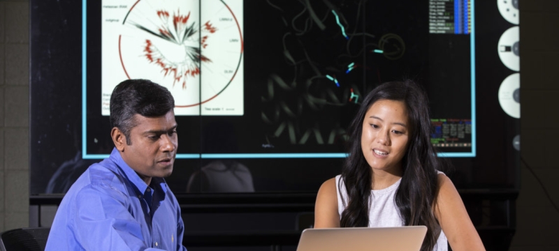 photo of two people seated looking at laptop