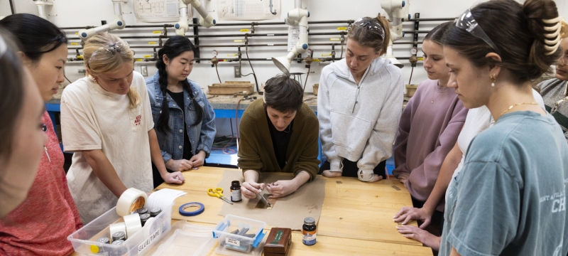 photo of nine people around a table, with small tools