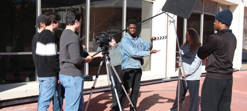 photo of film shoot with camera, people, clapper board, outdoors day