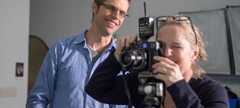 photo of man and student with camera