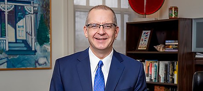 photo of man in office, with bookshelves, desk