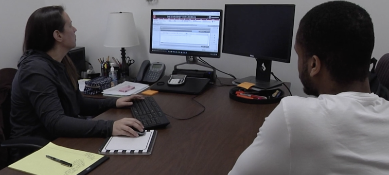 photo of two people in office with computer
