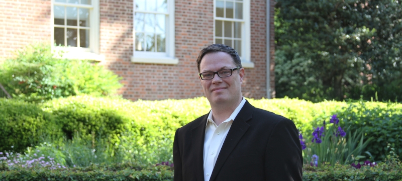 photo of man outdoors adjacent to brick building