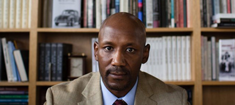 photo of man with bookshelves
