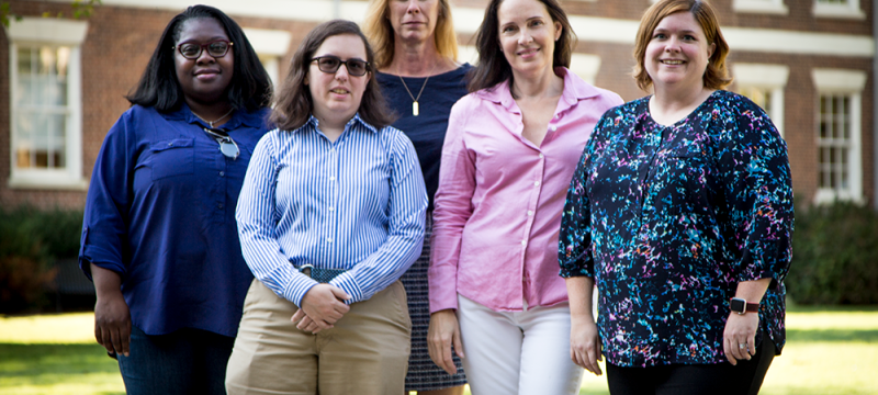 photo of four people in front of a building