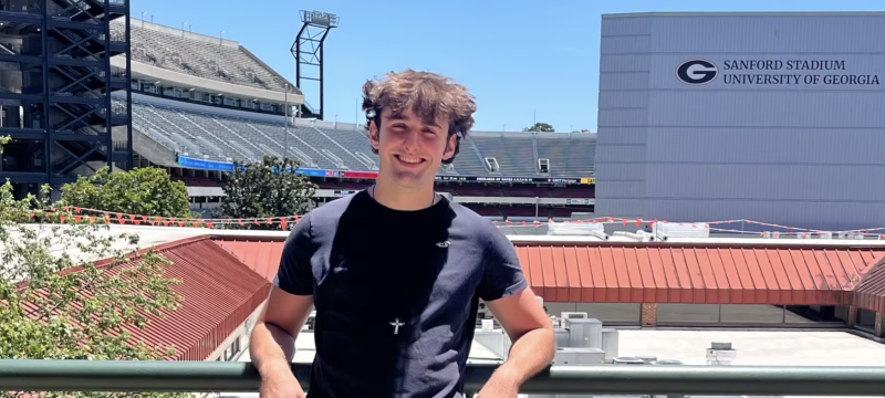 photo of man, stadium in background.