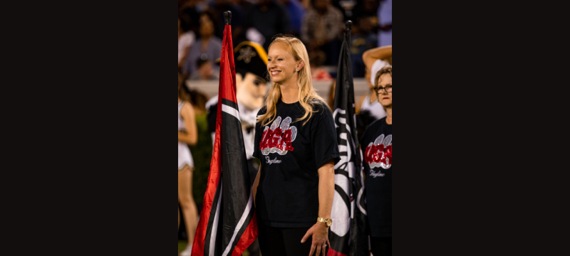 photo of woman on field, with flag