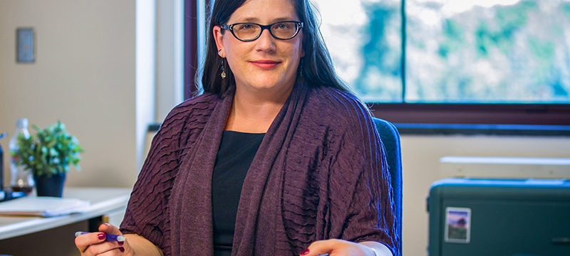 photo of woman in office with book and pen
