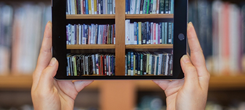 photo of two hands holding an iPad with books image