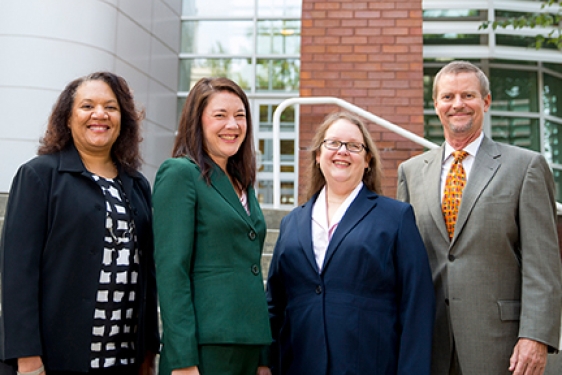 Four people in front of the Rusk center