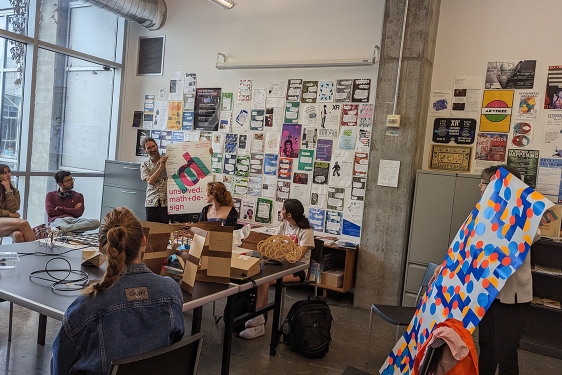 photo of people in discussion space, with images, notes and table