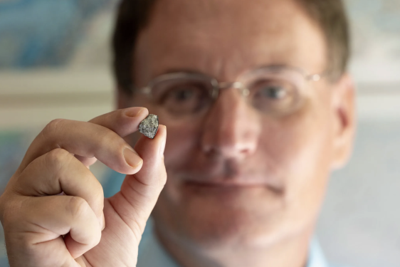 photo of man holding rock in foreground