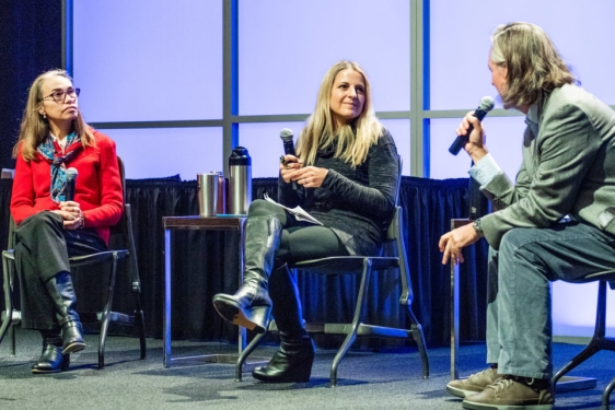 photo of three people on a stage with microphones