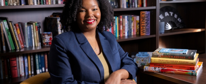 photo of woman in office, seated with books