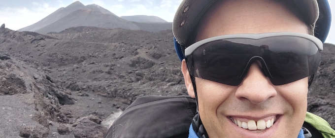 photo of man with volcanic mountain in background