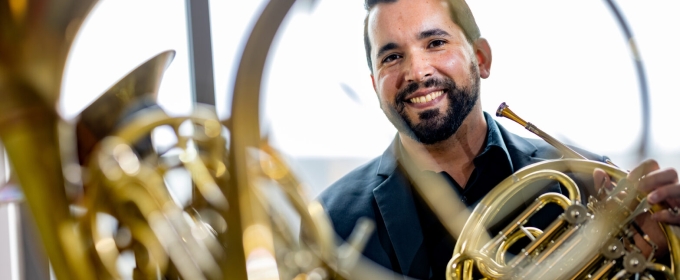 photo reflection of man with horn instrument