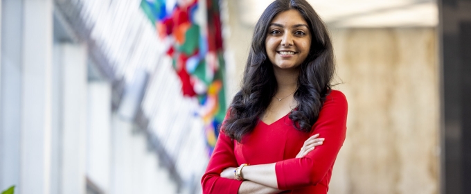 photo of woman, with row of flags in background 