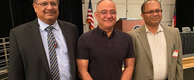 photo of three men, flag and podium in background