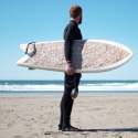 photo of person holding surfboard, ocean in background, day